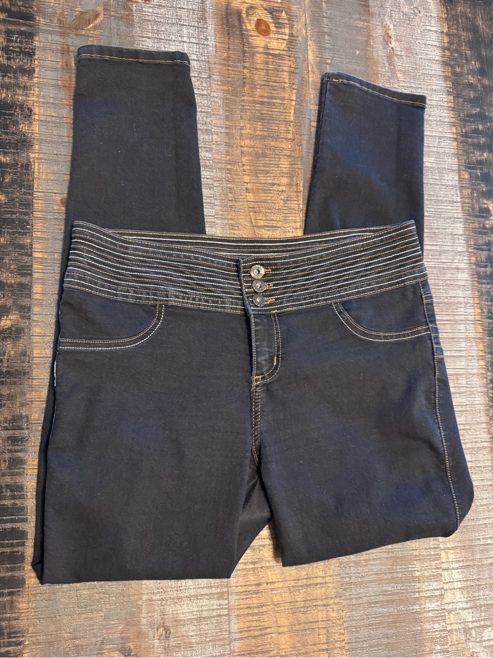 dark wash skinny jeans wide striped waistband secured by a triple-button closure